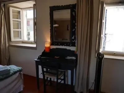 a bedroom with a desk with a mirror and a bed at La maison de Muriel in Rustrel
