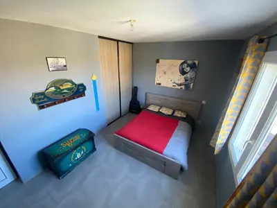 a small bedroom with a bed with a red blanket at Villa individuelle avec piscine privée proche du Ventoux in Blauvac