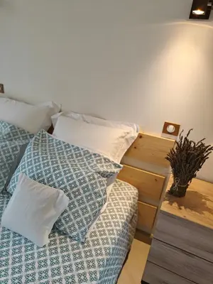 a bedroom with a bed with pillows and a table at Mas Sourso in Eygalières
