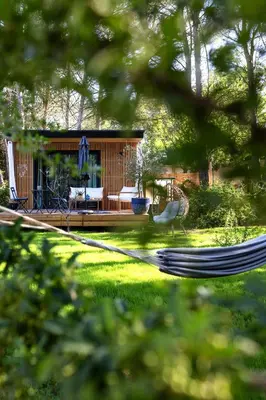 a house with a hammock in a yard at LES LODGES TAIZEN, séjour SPA- sans enfants in Saint-Cannat