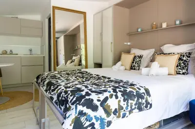 a bedroom with a large bed and a mirror at LES LODGES TAIZEN, séjour SPA- sans enfants in Saint-Cannat