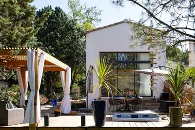 a house with a patio with a table and chairs at LES LODGES TAIZEN, séjour SPA- sans enfants in Saint-Cannat