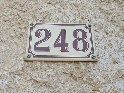a sign on the side of a stone wall at Pura vida in Mazan