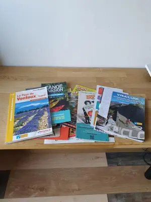 a pile of books sitting on a wooden table at Pura vida in Mazan