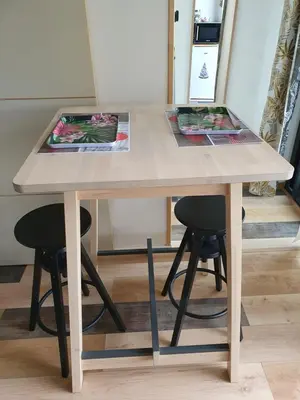 a wooden table with two stools around it at Pura vida in Mazan