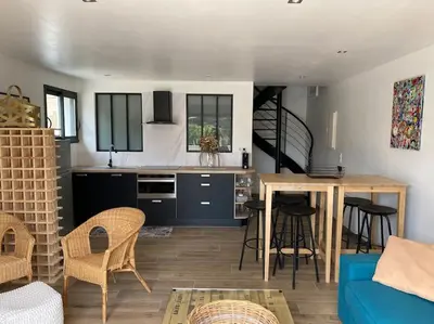 a kitchen and living room with a blue couch and a table at Maison avec ses 2 terrasses et sa piscine in Eyragues
