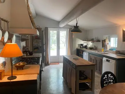 a kitchen with a counter and a table in it at La Bastide des Chênes Lacoste in Lacoste