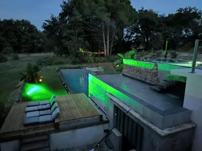 a swimming pool with blue water in a yard at Mas L'Escale des Dentelles in Aubignan