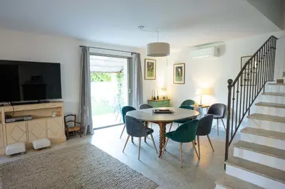 a living room with a table and chairs and a television at Villa Cocoon Lourmarin in Lourmarin