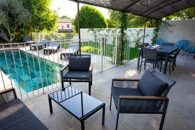 a patio with a table and chairs and a pool at Villa Cocoon Lourmarin in Lourmarin