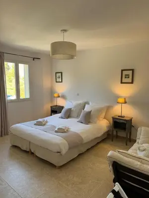 a bedroom with a large white bed and a couch at Villa Cocoon Lourmarin in Lourmarin