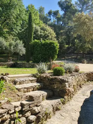 a stone garden with a stone wall and stairs at Mas du Tilleul - LUBERON in Cadenet