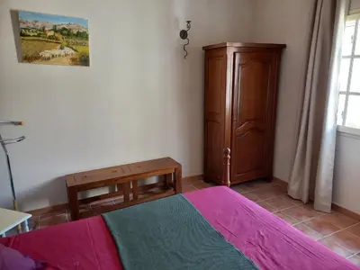 a bedroom with a bed and a wooden cabinet at Bienvenue en Provence in Monteux