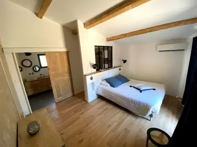 a bedroom with a bed and a table in a room at Mas de charme avec piscine au coeur des Alpilles in Eygalières
