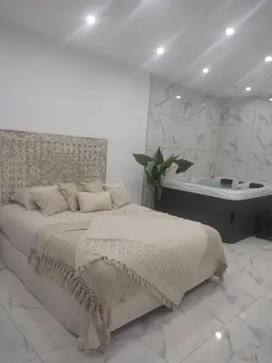 a white bedroom with a bed and a bath tub at Spa NESSA in Saint-Andiol