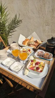 a table with a tray of food and glasses of orange juice at Spa NESSA in Saint-Andiol