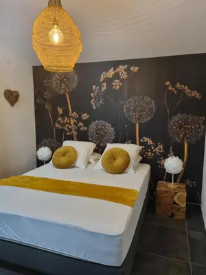 a bedroom with a bed with flowers on the wall at Ma Charmante Maison En Provence in Lançon-Provence