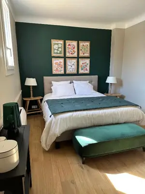 a bedroom with a large bed with a green wall at CABADOL - Appartement Aix centre historique - très calme - 50m cours Mirabeau in Aix-en-Provence