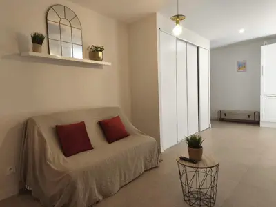 a living room with a couch with two red pillows at Appartement fontaine de Vaucluse in Fontaine-de-Vaucluse