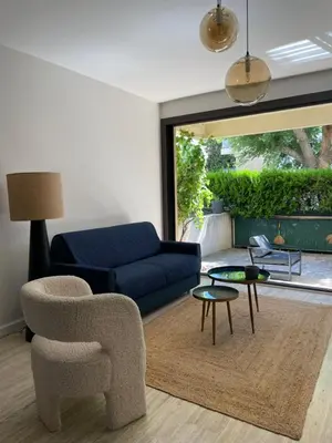 a living room with a blue couch and a chair at L’Écrin in Aix-en-Provence