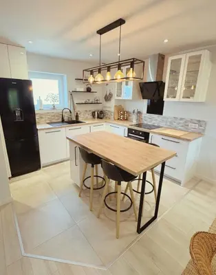 a kitchen with a wooden table and a black refrigerator at ''' Impasse d'un Instant ''' 8min Aix - Clim & Parking in Venelles