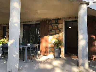 a patio with a table and chairs and a stone wall at Superbe bas de villaIX - Maison Odonata in Aix-en-Provence