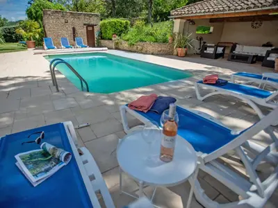 a swimming pool with chairs and a table and a bottle at Liodrey in Céreste