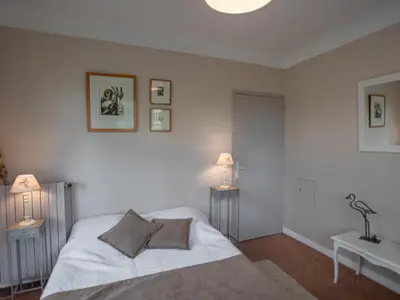 a white bedroom with a bed and two lamps at Liodrey in Céreste