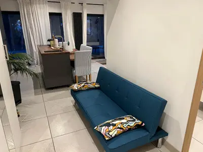 a blue couch in a living room with a desk at Entre Aix et Marseille in Rognac