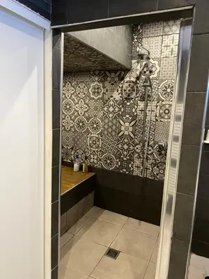 a bathroom with a shower with a tile wall at Entre Aix et Marseille in Rognac
