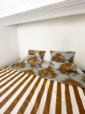 a bedroom with a bed with a striped mattress at Le Cocon Aixois in Aix-en-Provence