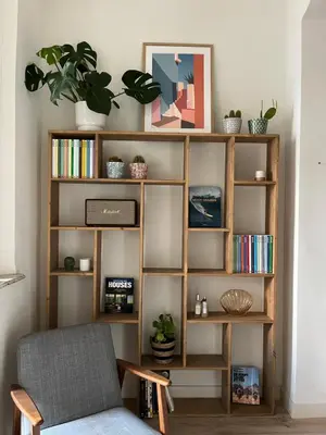 a book shelf with books and a chair in a room at Le Cocon Aixois in Aix-en-Provence