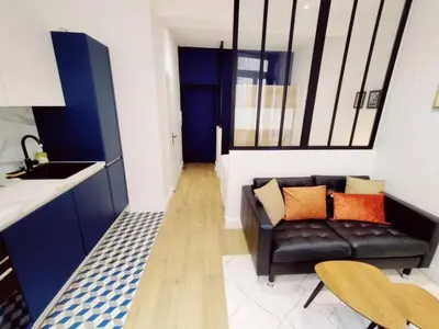 a living room with a couch and a kitchen at Le Boulegon by La Familia in Aix-en-Provence