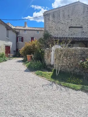 a stone house with a stone wall and a driveway at ENTRE VENTOUX ET LUBERON Chambre d'hôte in Sault-de-Vaucluse