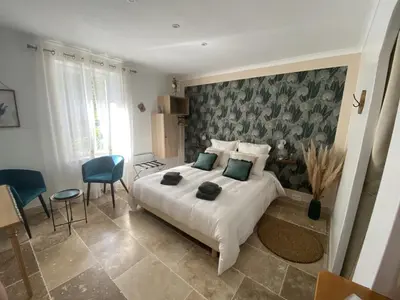 a bedroom with a bed and a table and chairs at Chambre d'hôtes Alizé, Le Moulin de Prédelles in Reillanne
