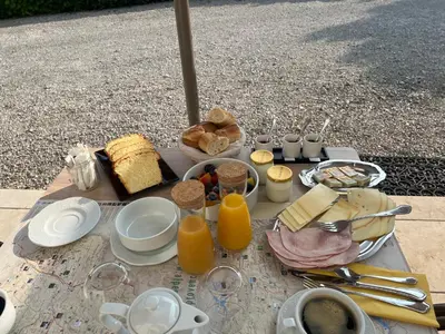 a table with food and drinks and orange juice at Chambre d'hôtes Alizé, Le Moulin de Prédelles in Reillanne