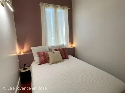 a bedroom with a white bed with pillows and a window at Charmant appartement T2 / 58 m2 / 4 personnes in Aix-en-Provence
