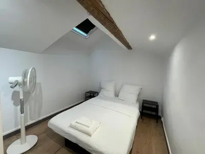 a bedroom with a white bed and a fan at Spacieux appartement T4 / 70 m2 8 personnes in Aix-en-Provence