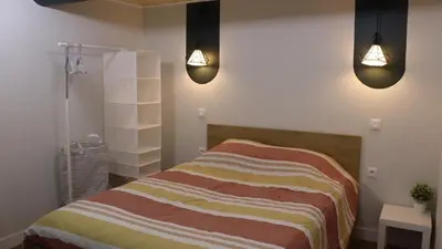 a bedroom with a bed with two lights on it at Studio rénové maison de village du Luberon in Villelaure