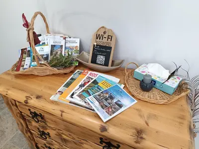 a wooden table with magazines and books on it at Écrin de nature sous les pins in Aurons