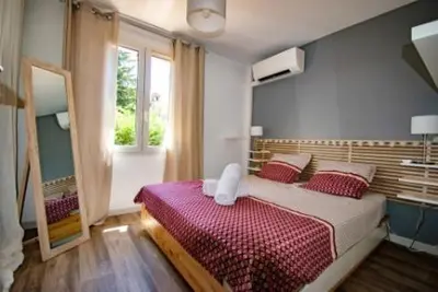 a bedroom with a large bed with red pillows at Les quatres loges in Aix-en-Provence