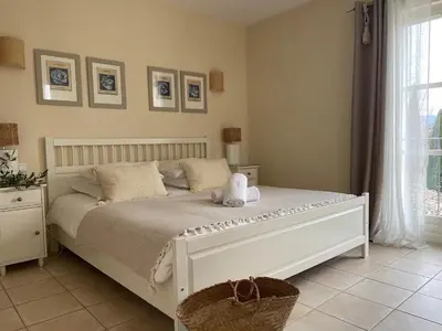a bedroom with a white bed with two stuffed animals on it at La Villa Baronnette in Cabrières-dʼAvignon