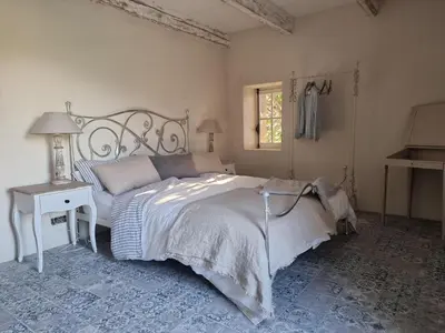 a bedroom with a bed and a table and a window at Mas Cerisiers in Saint-Martin-de-Castillon