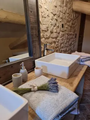 a bathroom with a white sink on a wooden counter at Mas Cerisiers in Saint-Martin-de-Castillon