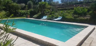 a swimming pool with two chairs in a yard at Gîtes L'HERMITAGE in La Tour-dʼAigues