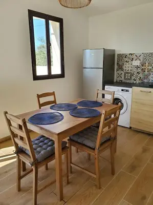 a kitchen with a wooden table with chairs and a refrigerator at Rêve en Lubéron in Lauris