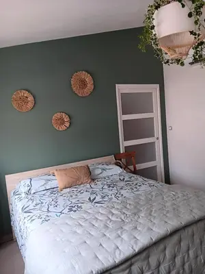 a bedroom with a bed and two mirrors on the wall at La villa MARIE in Cavaillon