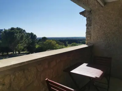 a table and chair sitting on a wall with a view at LA GRANGETTE in Velleron