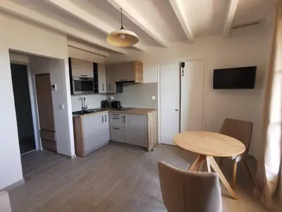 a kitchen with a wooden table and a table and chairs at LA GRANGETTE in Velleron