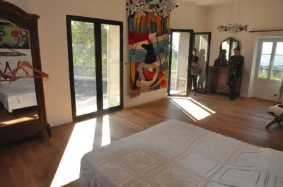 a living room with wooden floors and paintings on the walls at Pavillon de Beauregard in Aix-en-Provence